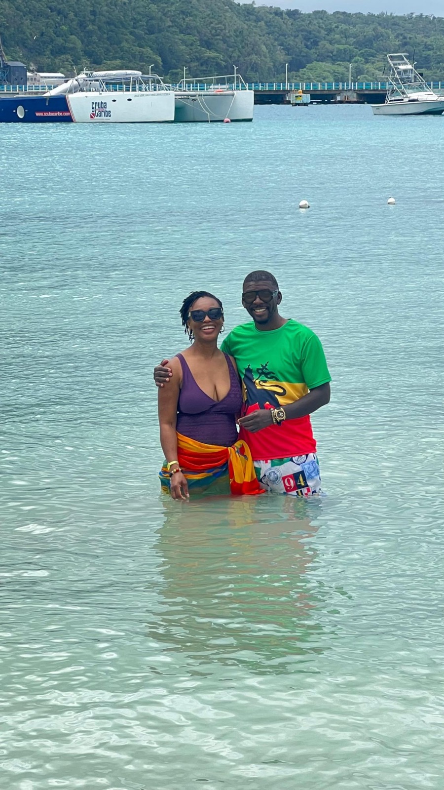The couple standing in clear turquoise water