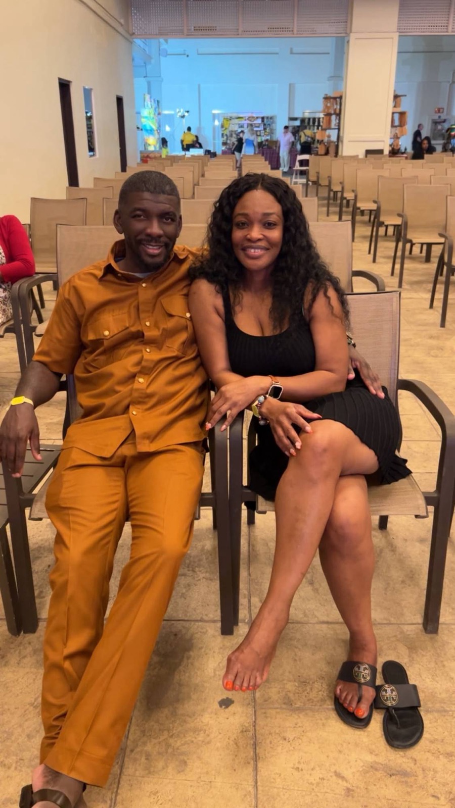 The couple seated together, Edmund in an orange suit
